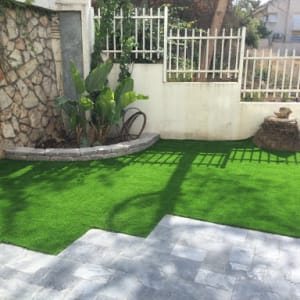 גינה עם דשא סינתטי וצמחים ירוקים