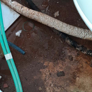 צינורות ירוקים ושחורים על רצפה רטובה