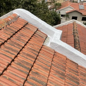 רעפים כתומים על גג עם קיר לבן