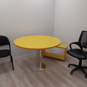 חדר עם שולחן עגול צהוב ושני כיסאות