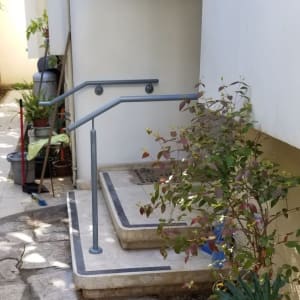 מעקה מתכת אפור ליד מדרגות אבן