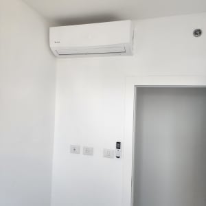 מזגן מותקן על קיר לבן בחדר פנימי