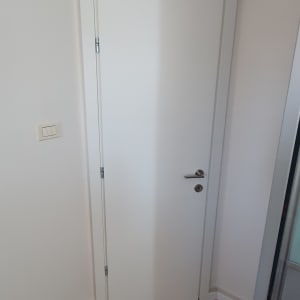 דלת לבנה עם ידית מתכת בחדר פנימי