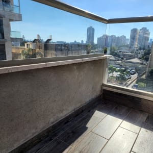 מעקה זכוכית במרפסת עם נוף עירוני