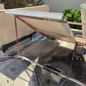 קולט שמש מותקן על גג עם צינורות וחיבורים