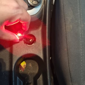 יד מחזיקה נורה אדומה ליד מושב רכב