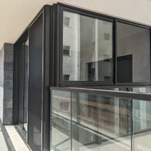 חלונות אלומיניום במרפסת עם מסגרת שחורה