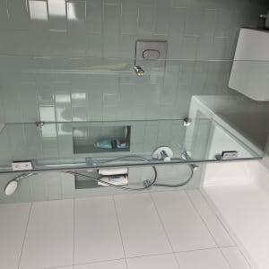 מקלחת עם ראשי מקלחת ומדף זכוכית