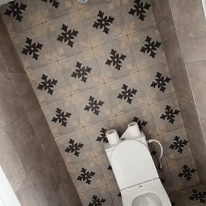 אסלה עם נייר טואלט על רקע אריחים מעוצבים