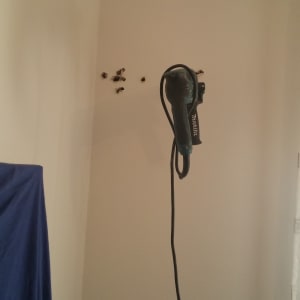 קיר עם חורים ומקדחה תלויה