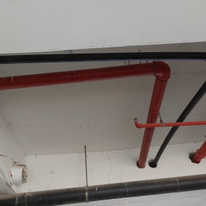 צינורות אדומים ושחורים בתקרה לבנה