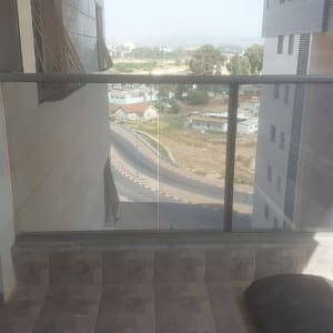 מעקה זכוכית במרפסת עם נוף עירוני