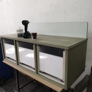 ארון עץ עם מגירות, מקדחה וברגים על השולחן