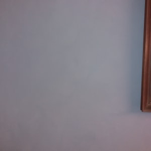 קיר כחול עם מסגרת עץ בצד ימין