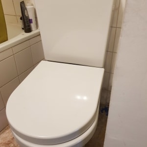 אסלה לבנה בחדר אמבטיה עם אריחים לבנים