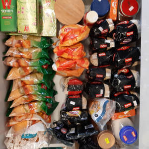 מגוון מוצרים מאורגנים במגירה, כולל תבלינים וקטניות.