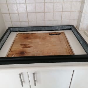 משטח שיש לבן עם מסגרת שחורה על ארון מטבח