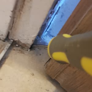 כלי עבודה צהוב ליד דלת עם סימני רטיבות