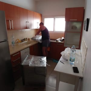 אדם אורז חפצים במטבח לקראת מעבר דירה