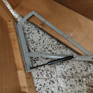 מנגנון מתכת עם בוכנה על רצפת אריחים