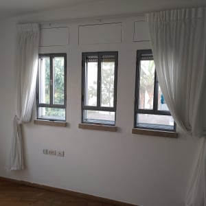 חדר עם קירות לבנים ווילונות לבנים