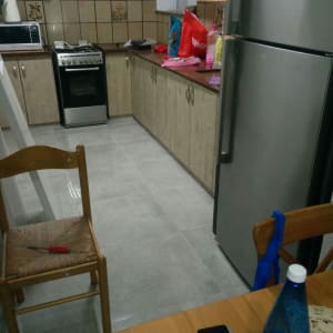 מטבח עם אריחים חדשים וכלי עבודה על כיסא