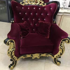 כורסה מרופדת בבד קטיפה אדום עם כריות תואמות