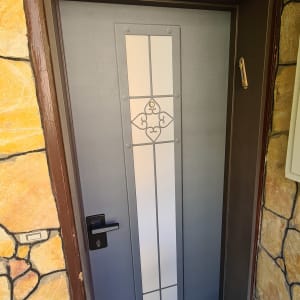 דלת מתכת אפורה עם חלון זכוכית מעוצב