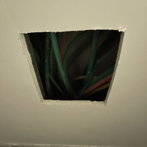 חור בתקרה עם חוטי חשמל ירוקים וכתומים