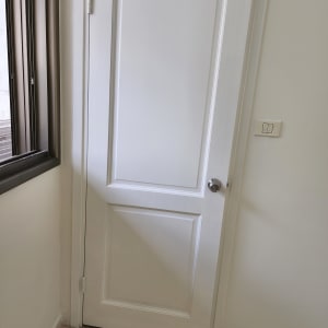 דלת לבנה צבועה עם ידית מתכת