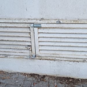 מסגרת מתכת עם תריסים על קיר בטון