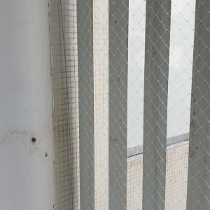 רשת מתכת מותקנת על קיר למניעת כניסת יונים