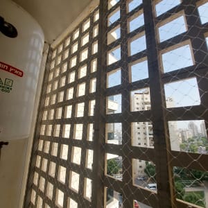 רשת מתוחה על חלון למניעת כניסת יונים