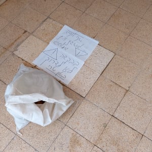 שק בנייה על רצפה עם אריחים, דף עם שרטוטים