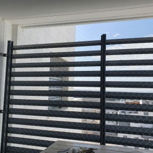 רשת מתכת מותקנת על גדר למניעת כניסת יונים