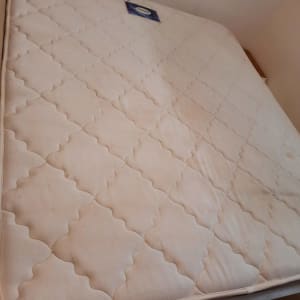 מזרן לבן עם כתמים קלים על מיטה