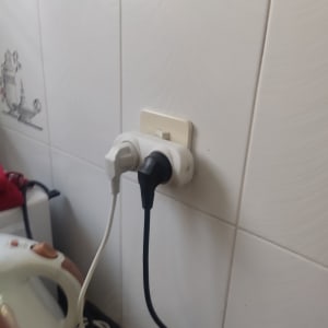 שני תקעים מחוברים לשקע חשמלי על קיר