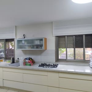 וילון לבן מעל חלון במטבח מודרני