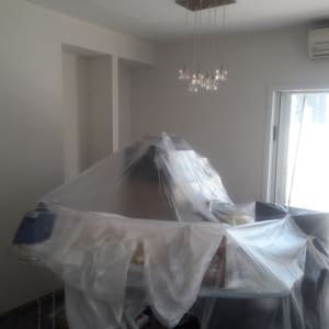 חדר עם רהיטים מכוסים בניילון לקראת צביעה