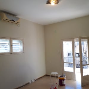 דלי צבע, כיסא פלסטיק, בקבוקי שתייה על הרצפה