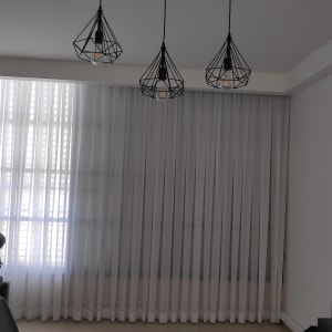 וילון לבן שקוף תלוי על חלון גדול