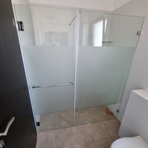 מקלחון זכוכית עם דלתות חלביות ומוט מגבת