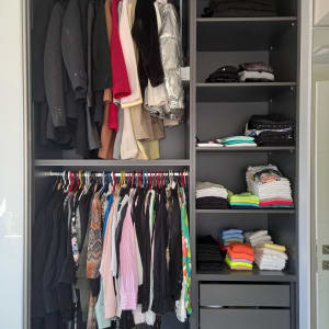 ארון בגדים מאורגן עם בגדים תלויים ומקופלים