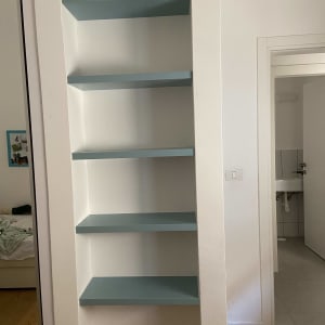 מדפים כחולים מותקנים בקיר לבן