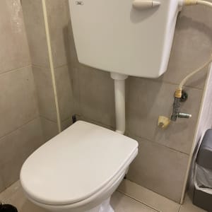 אסלה עם מיכל הדחה וצינור מים מחובר