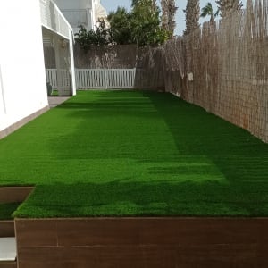 דשא סינתטי ירוק על משטח מוגבה בגינה