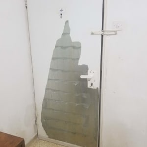 דלת עם ציפוי מתקלף בחלקה התחתון