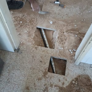 עבודת אינסטלציה עם צינורות חשופים ברצפה