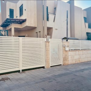 גדרות לבנים עם פסים אופקיים בחזית הבית