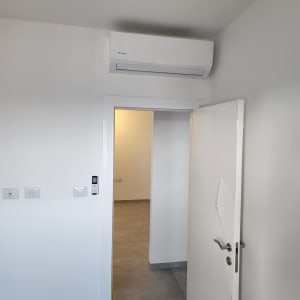 מזגן מותקן על קיר מעל דלת פתוחה